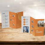 Zigzagvouw folders met bedrijfsinformatie op een houten tafel.